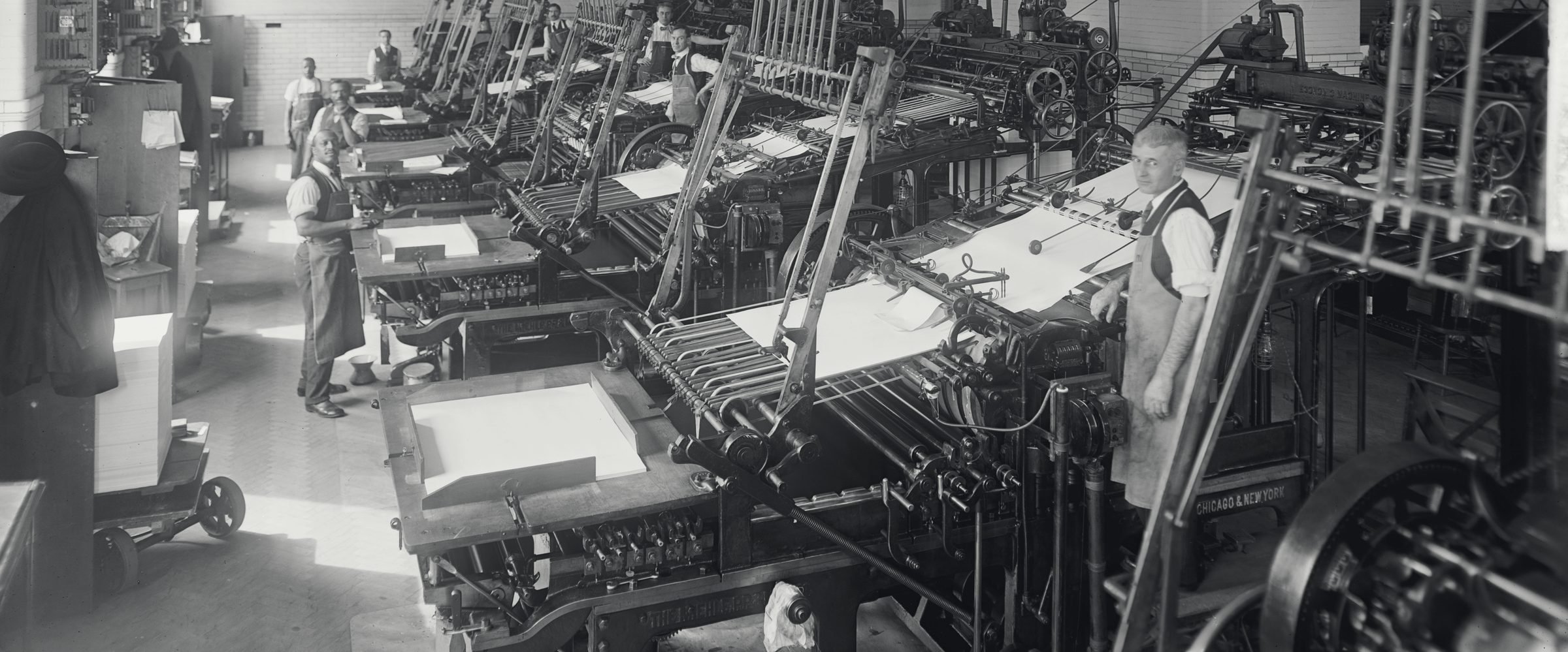 Pressmen at rows of printing presses in the Government Printing Office