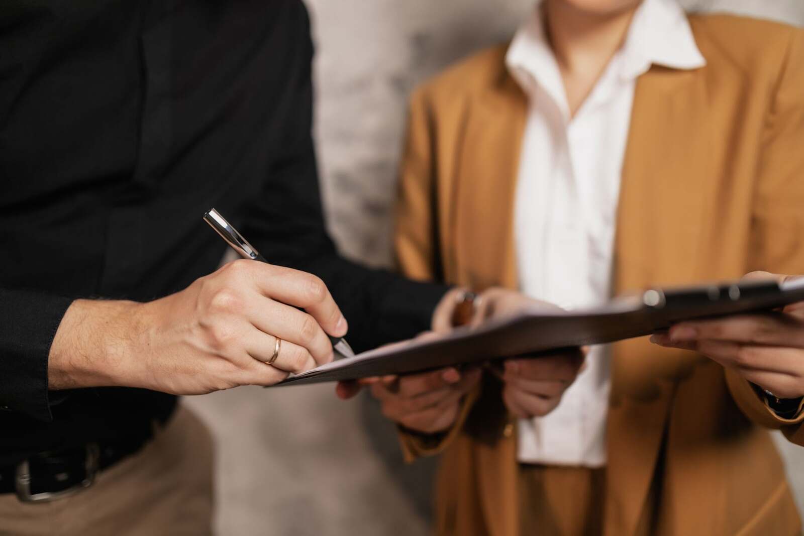 Close-up of hands signing an approval document on a clipboard, standing in for the FDA's nonprescription approval of Brytly