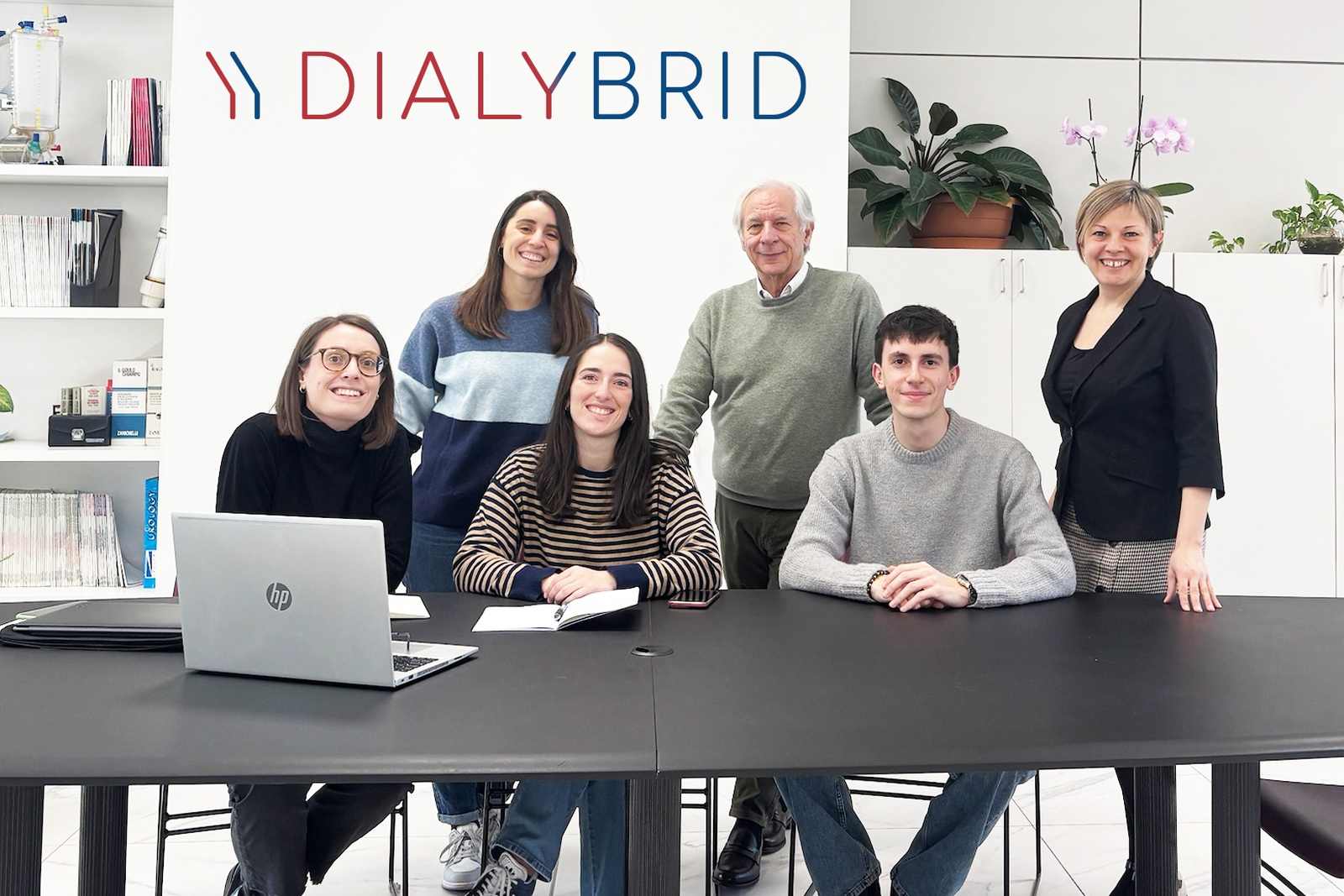Six members of the Dialybrid team gather around a conference table in the company's office