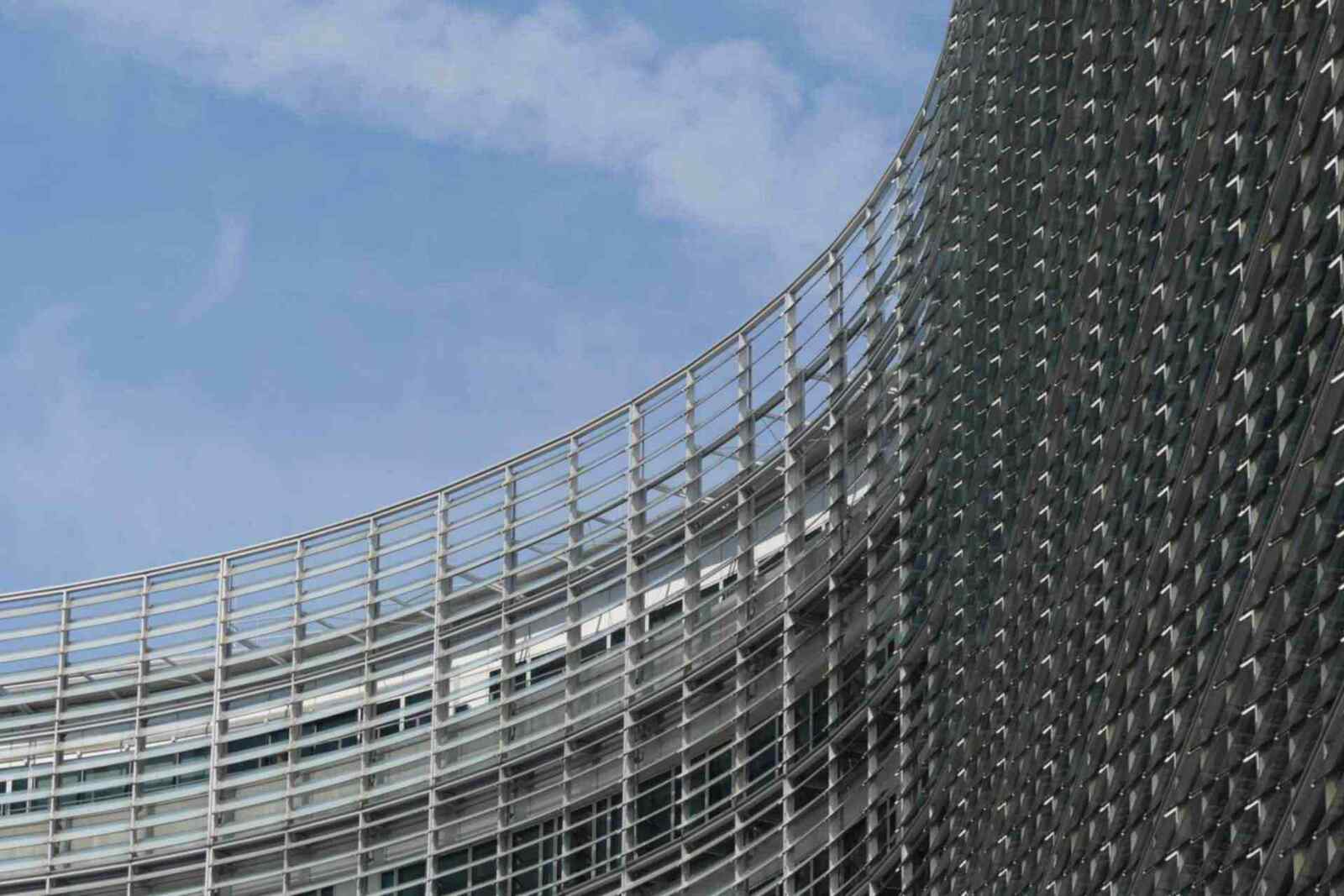 A close-up of a curved EU institutional building facade against a blue sky, a generic stand-in for EU regulatory policy