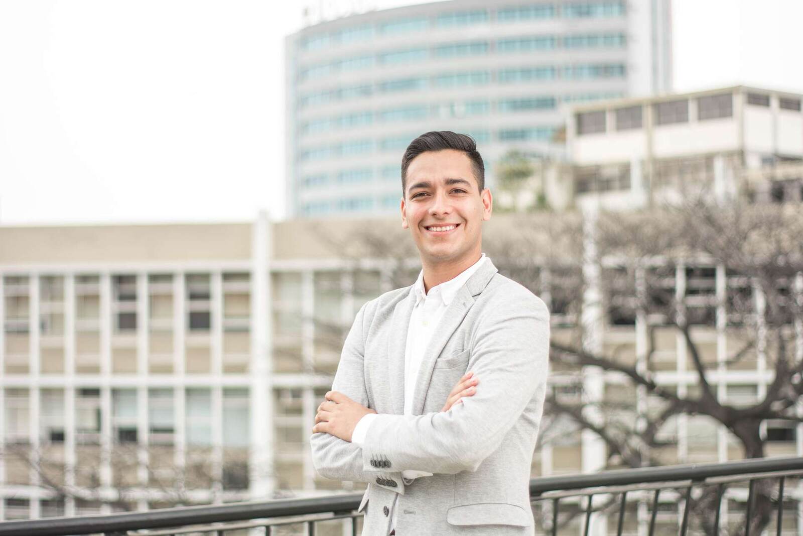 A smiling business professional standing on a city balcony, representing icotec's device-industry leadership