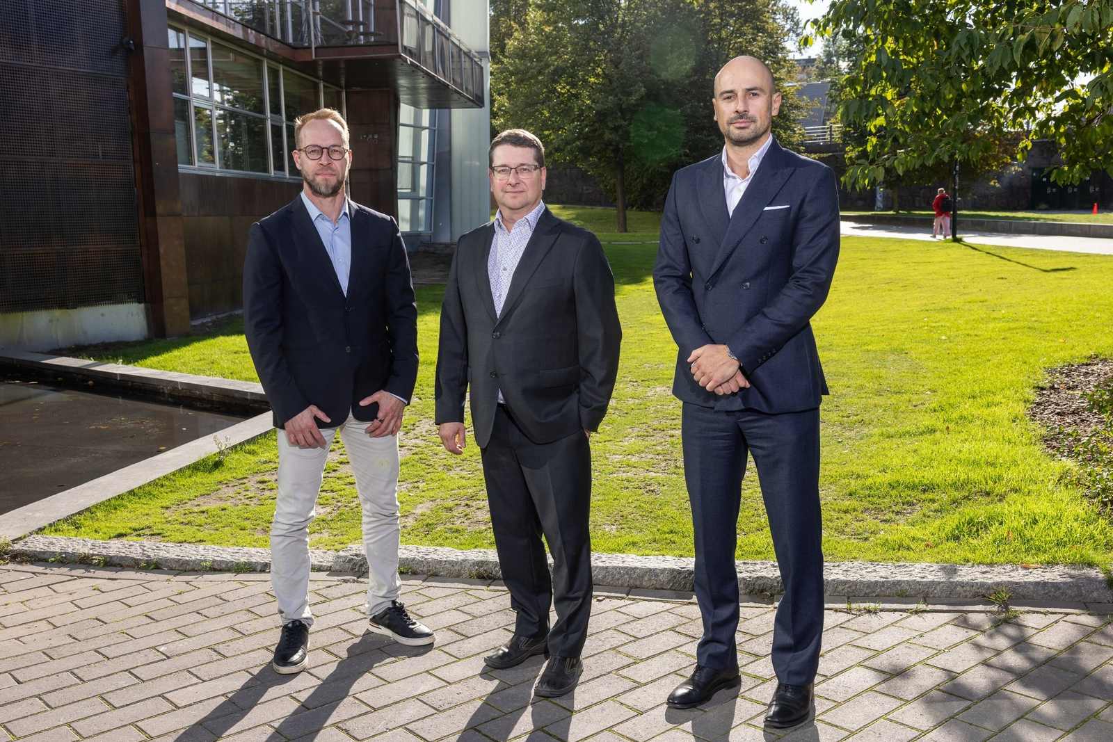 Kasvu Therapeutics executives Matti Karvonen, Jami Mandelin and Georgios Trichas stand on a path outside the company's building in Helsinki