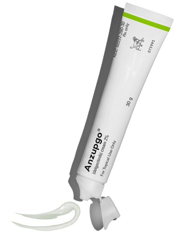 A tube of Anzupgo (delgocitinib) cream 2% lying on white with its cap off and a ribbon of cream beside it.