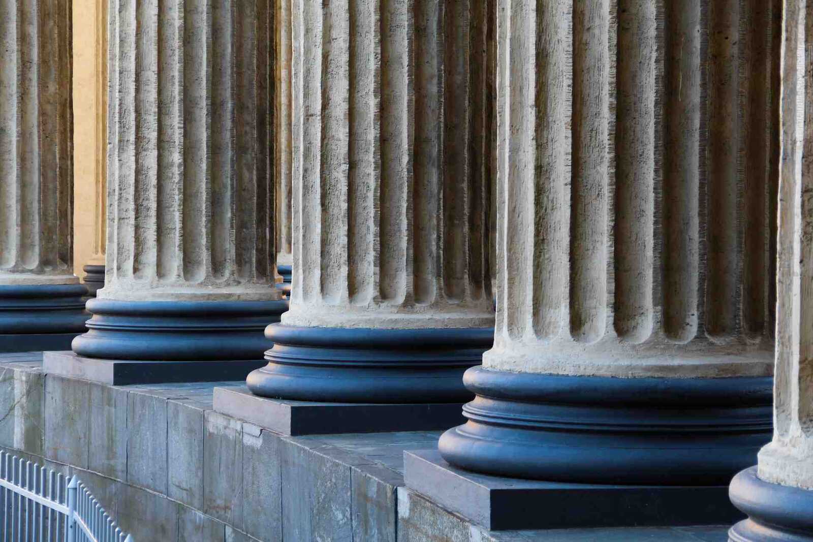 Fluted stone columns of a classical institutional building in sunlight
