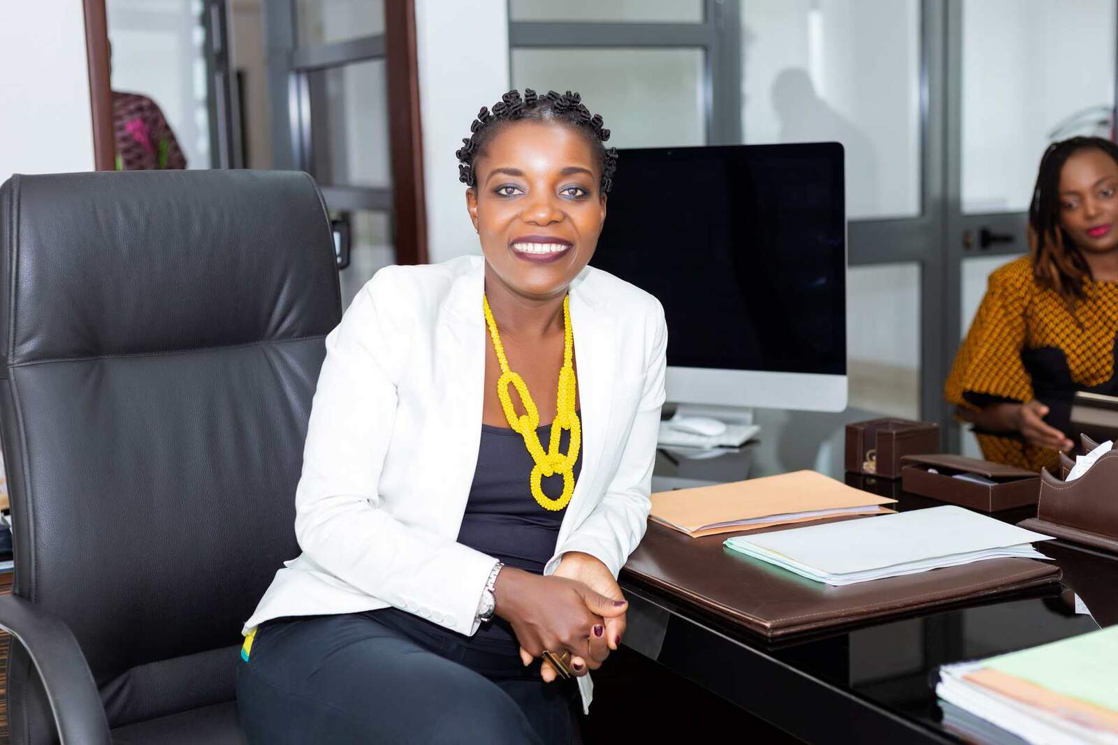 A smiling executive in a white blazer at an office desk, a generic stand-in for a BioCryst commercial announcement