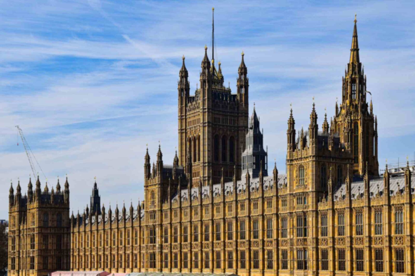 The Houses of Parliament and Victoria Tower in Westminster, London, under a blue sky
