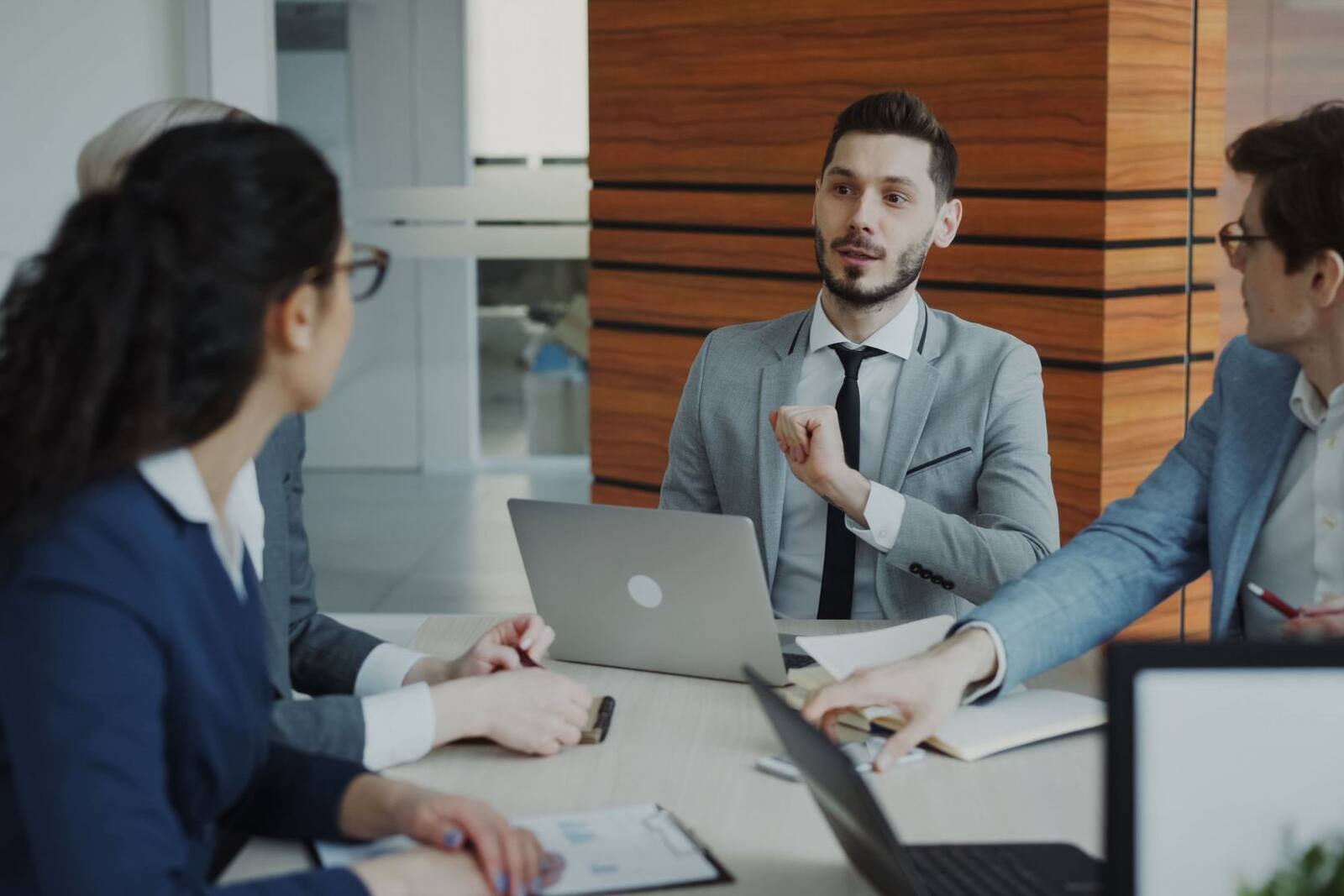 A team reviewing a product rollout around a conference table with laptops open, a generic corporate stand-in — not a depiction of SEKISUI Diagnostics' own staff or lab