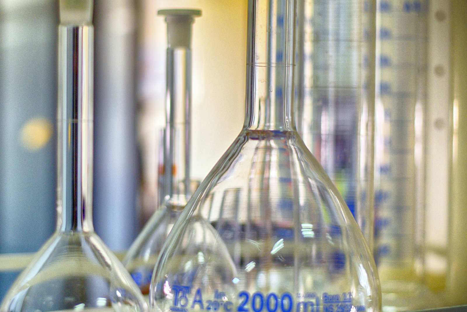 Volumetric flasks in shallow focus, lit in soft green