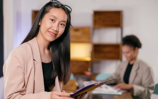 A young professional holding a folder in a bright office, a generic stand-in for a BioCryst commercial team