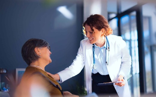 A clinician reviewing prescribing information beside pill bottles and a stethoscope