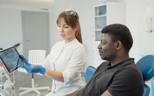 A clinician pointing out findings on a tablet screen to a patient, a generic stand-in for Coreline Soft's AI imaging review