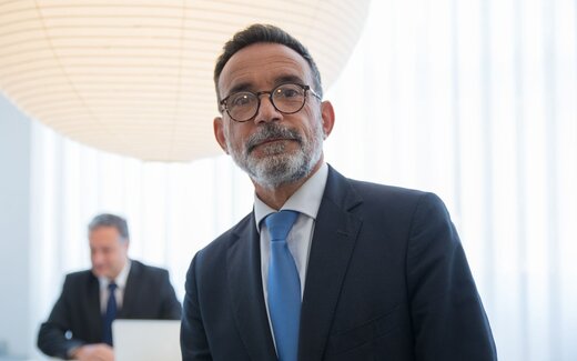 A pharmaceutical executive in an office setting, standing in for the CHMP's review of Eli Lilly's regulatory filing