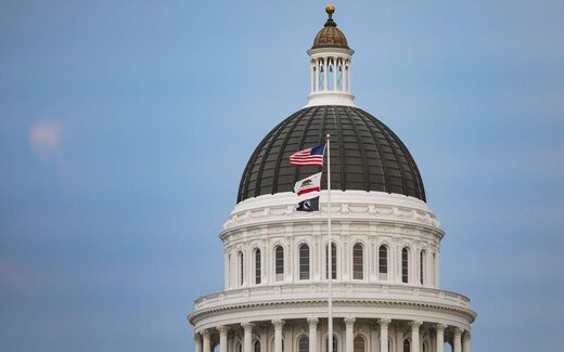 A state capitol building's dome under a blue sky, representing government regulatory action