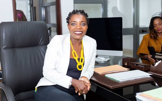 A smiling executive in a white blazer at an office desk, a generic stand-in for a BioCryst commercial announcement