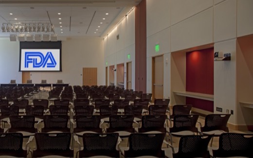 Rows of empty seats facing an FDA-branded screen in the White Oak Great Room