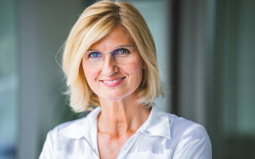 A physician in professional attire in a clinical office setting