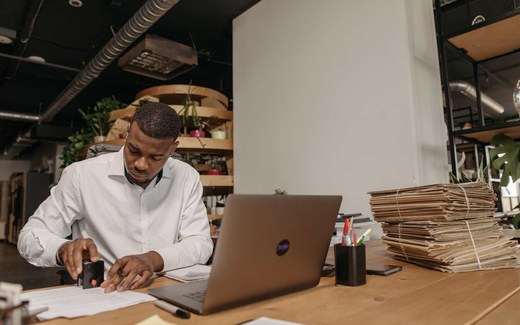 An office worker stamps an official document at a desk