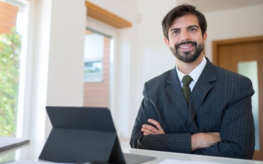 A pharmaceutical executive in a bright office, standing in for UCB's autoinjector approval announcement