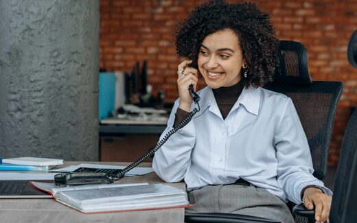 A professional on a desk phone, a generic stand-in for a clinician or pharmacist fielding a prescription question
