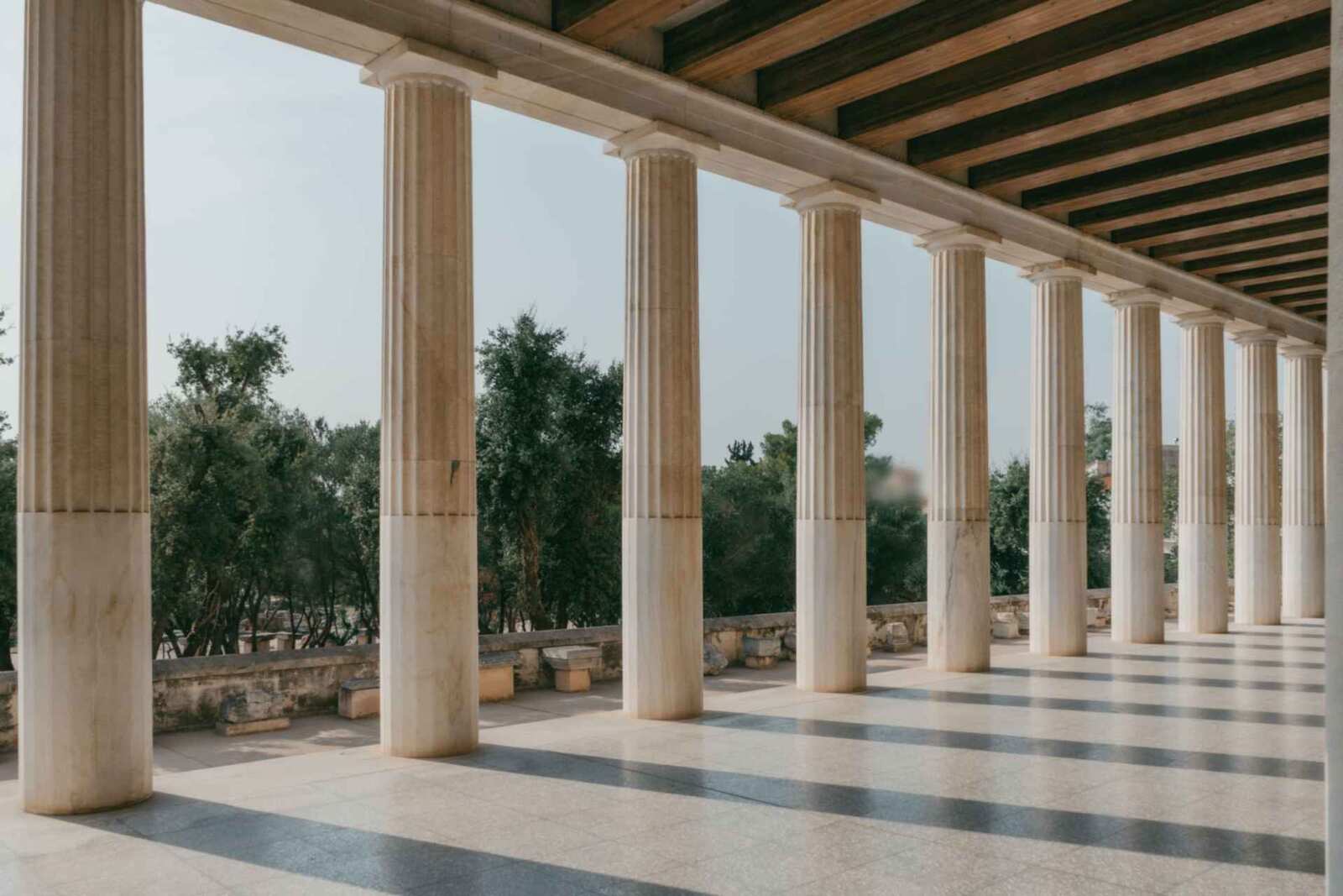 A sunlit colonnade of classical columns, used as a generic regulatory-decision backdrop