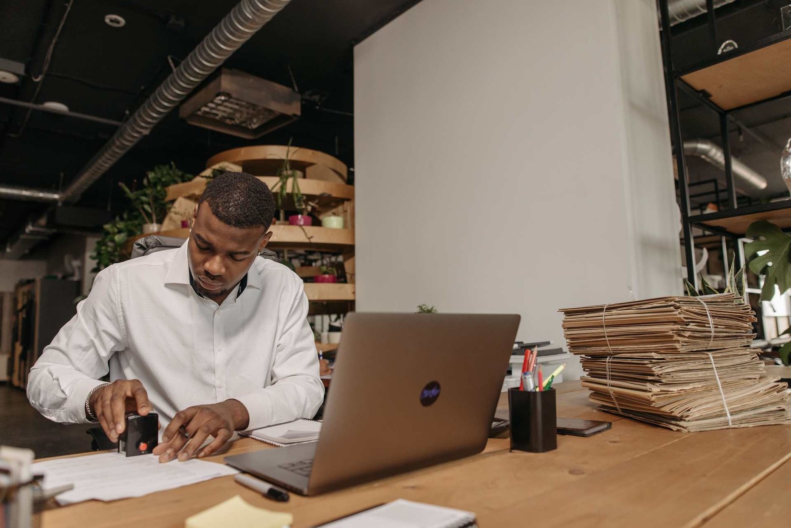 An office worker stamps an official document at a desk