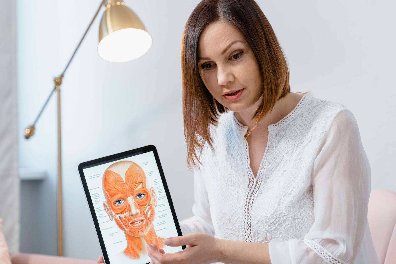 A clinician reviews an anatomical illustration on a tablet with a patient — a generic stand-in for a clinic counseling visit, not an achondroplasia-specific scene