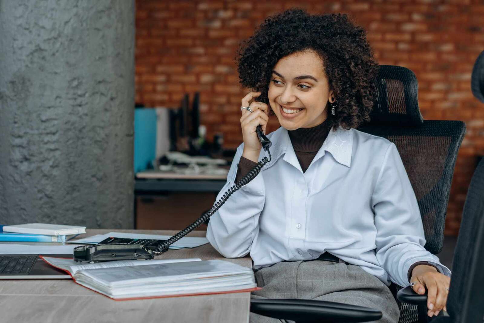 A professional on a desk phone, a generic stand-in for a clinician or pharmacist fielding a prescription question