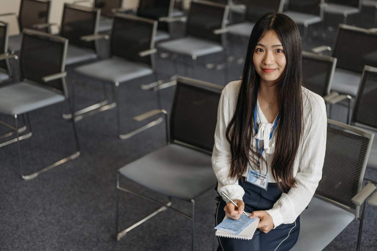 A smiling delegate in a white blouse with an 