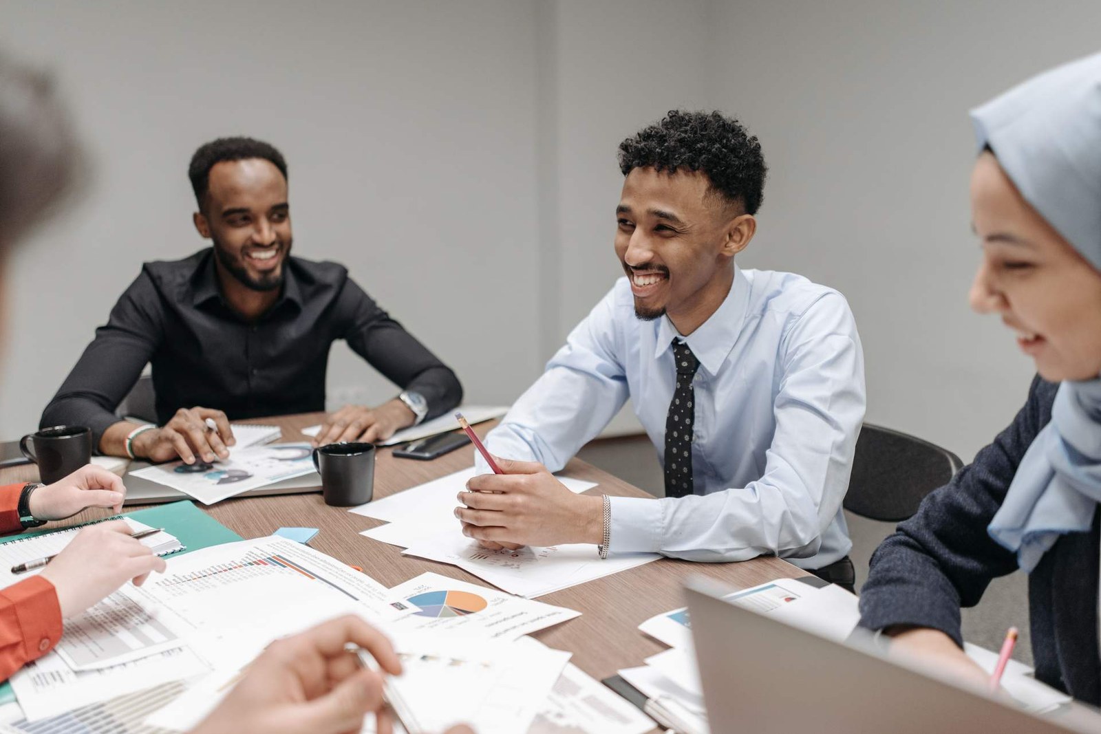 Colleagues review printed charts and data around a bright meeting table