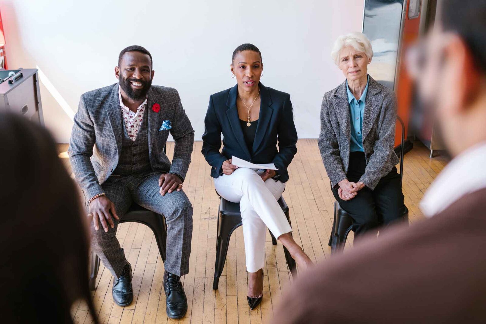 Three panellists in business dress seated before an audience during a panel session