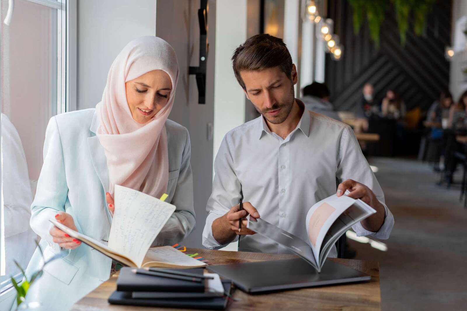 Two colleagues review handwritten notes and a printed document together at a table