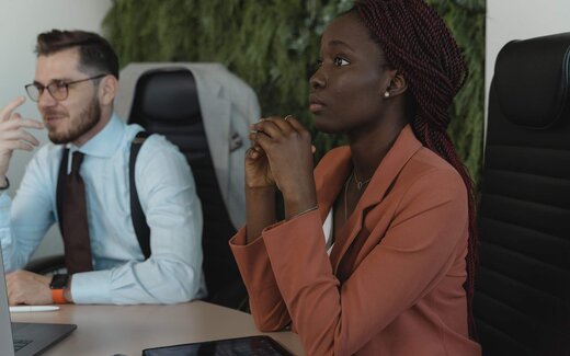 Two delegates listening attentively in a bright meeting room