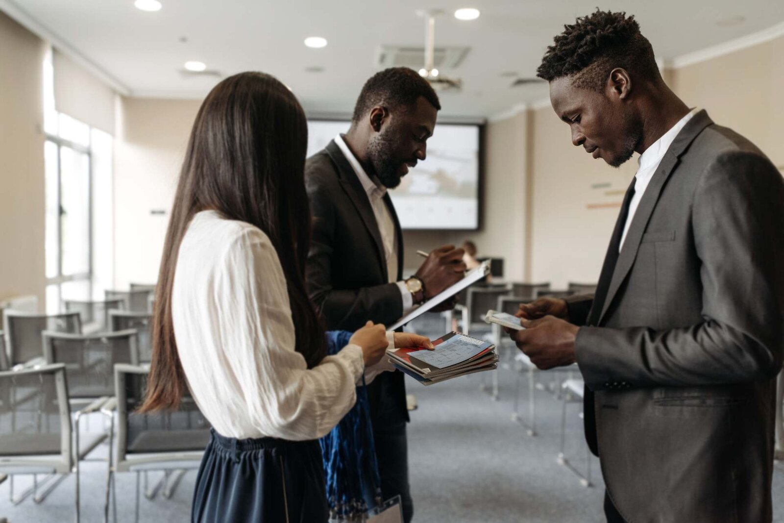 Delegates exchange programmes and lanyards at a training session registration table